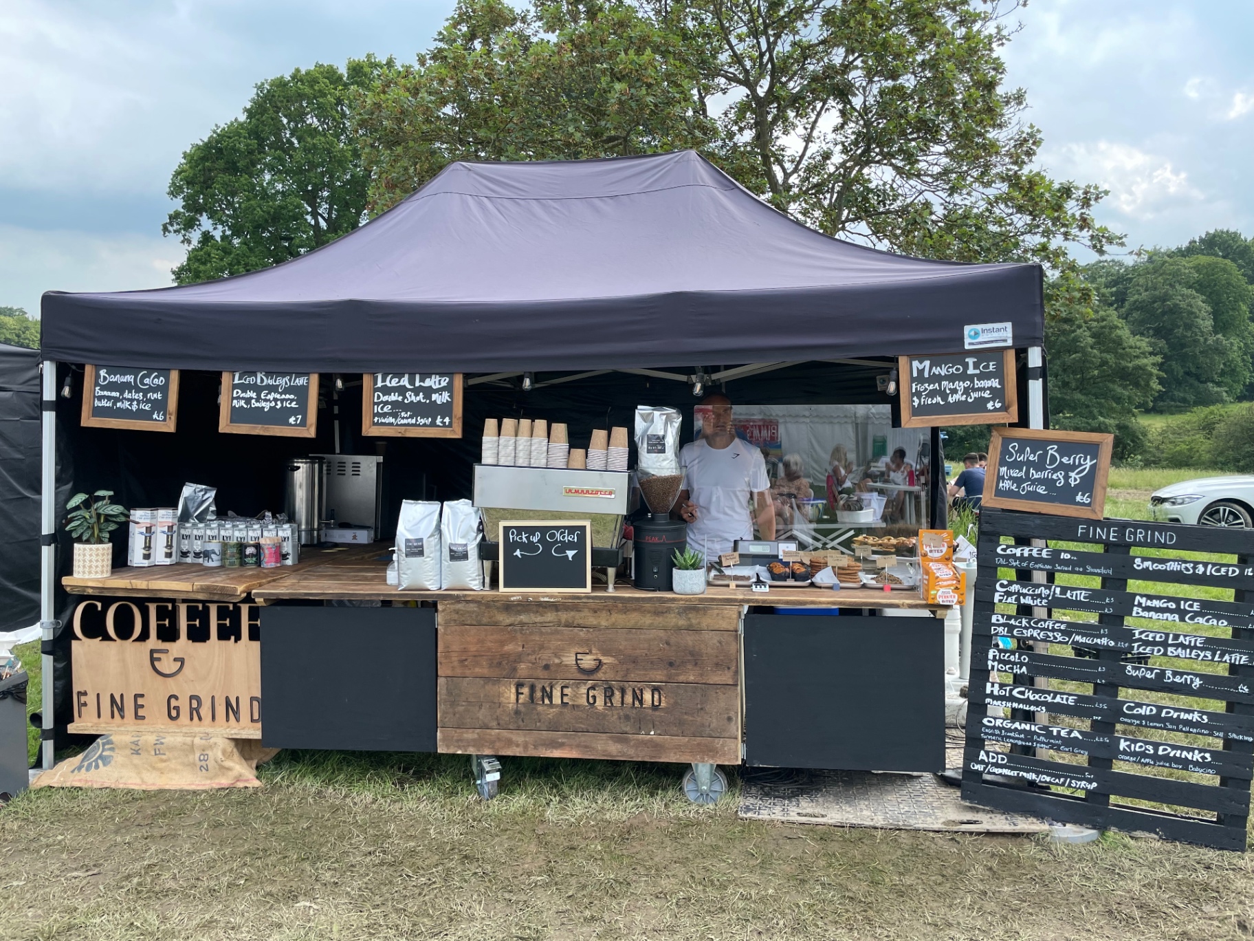 Wide summer view of the Fine Grind event bar with full menu board, pastries and espresso setup