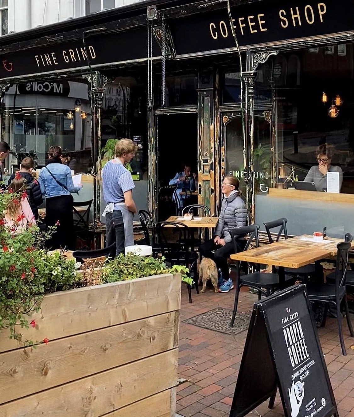 Fine Grind coffee shop terrace in Tunbridge Wells with customers, outdoor tables and the black gilded shopfront